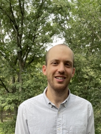 Photo Of Shachar Levanon Standing in Front Of Leaves