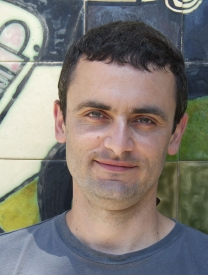 Photo Of Joseph Benatov Standing In Front Of A Painted Wall